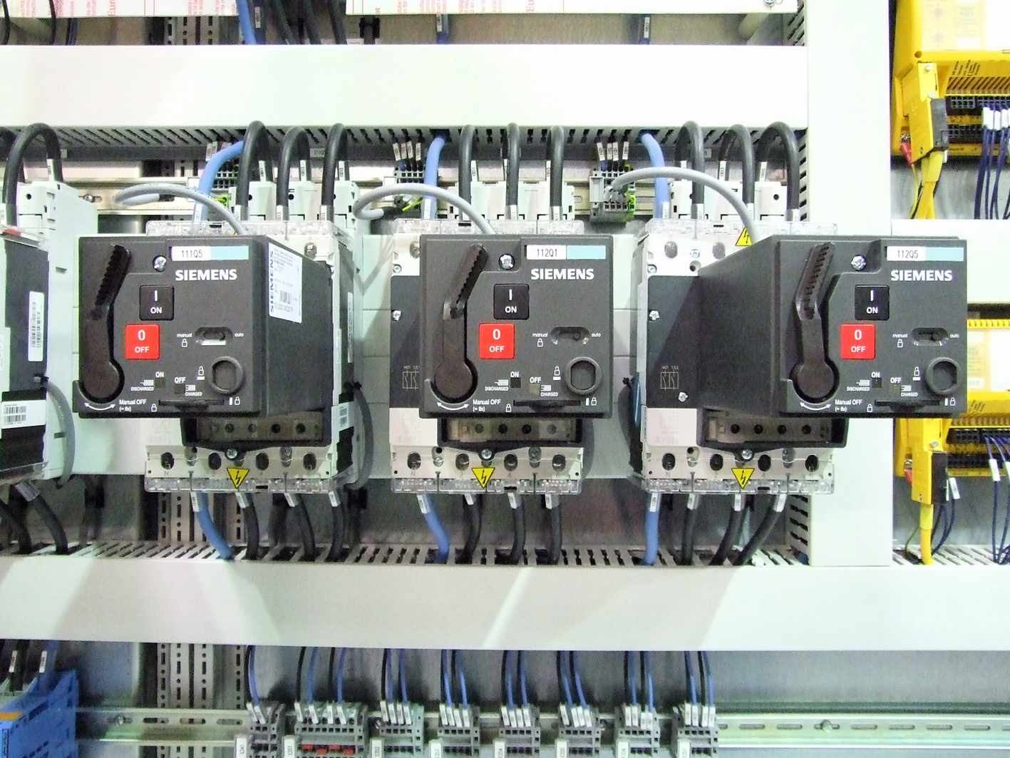 The wired interior of a control panel for automated equipment