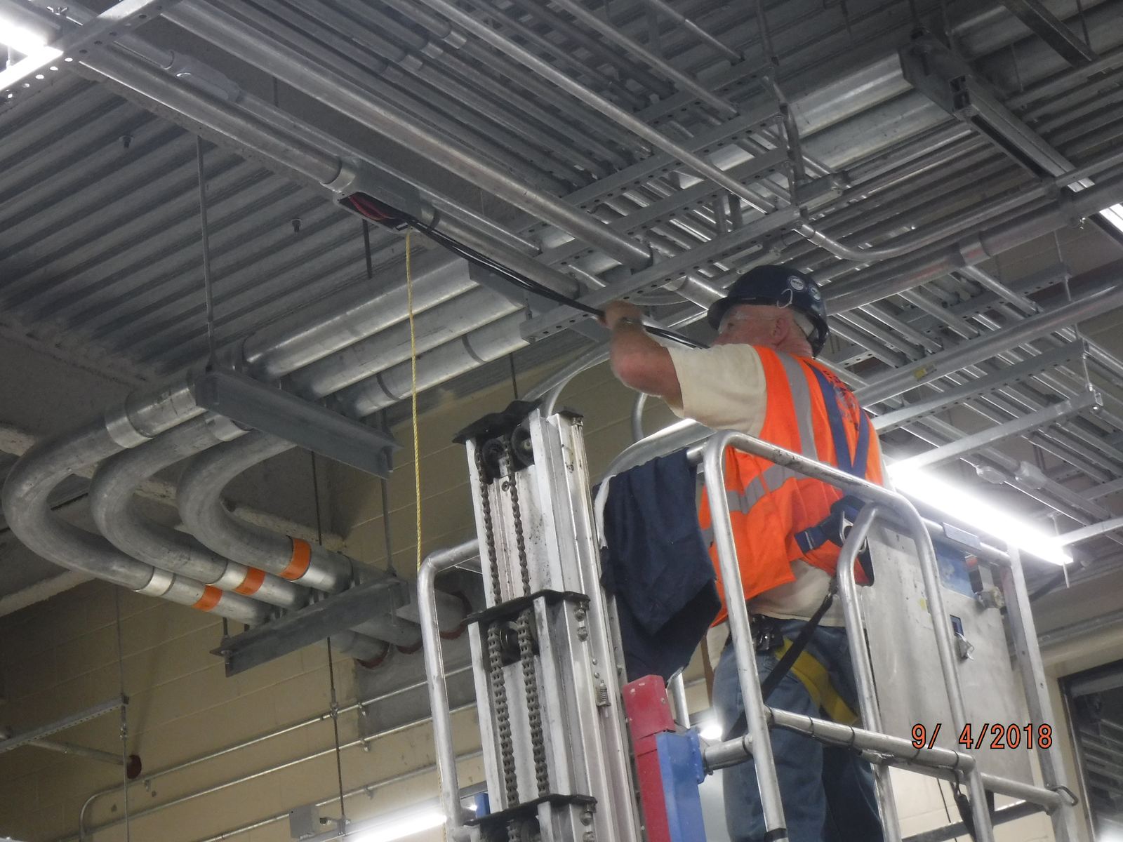 A technician installing control wires in a switchgear room during a planned upgrade